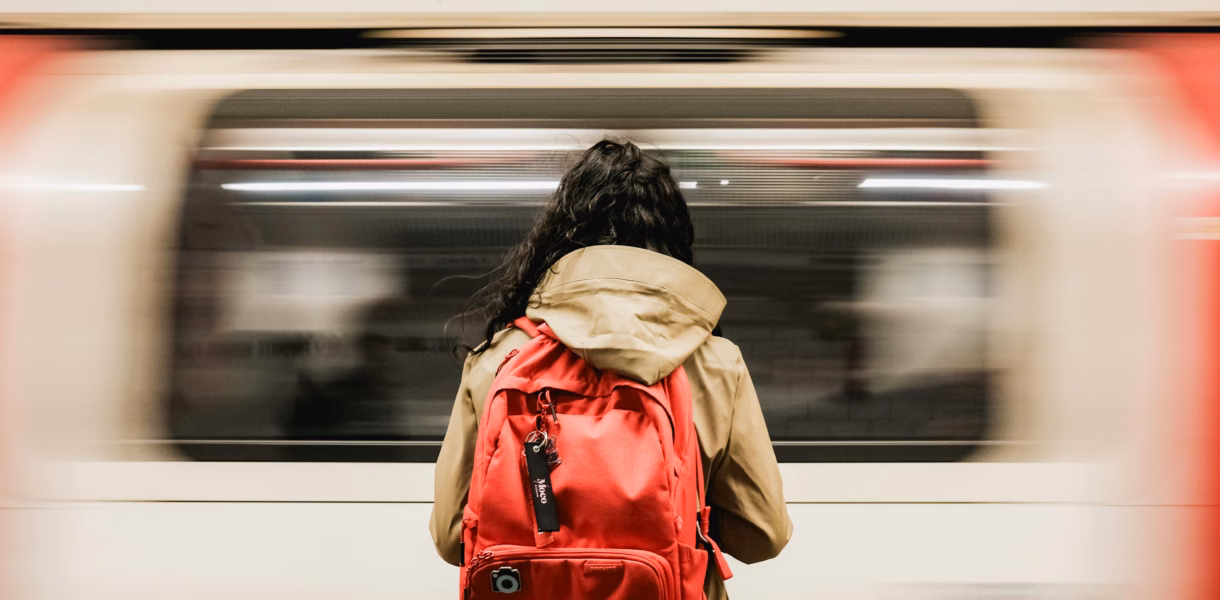 a person waiting for the train with a backpack