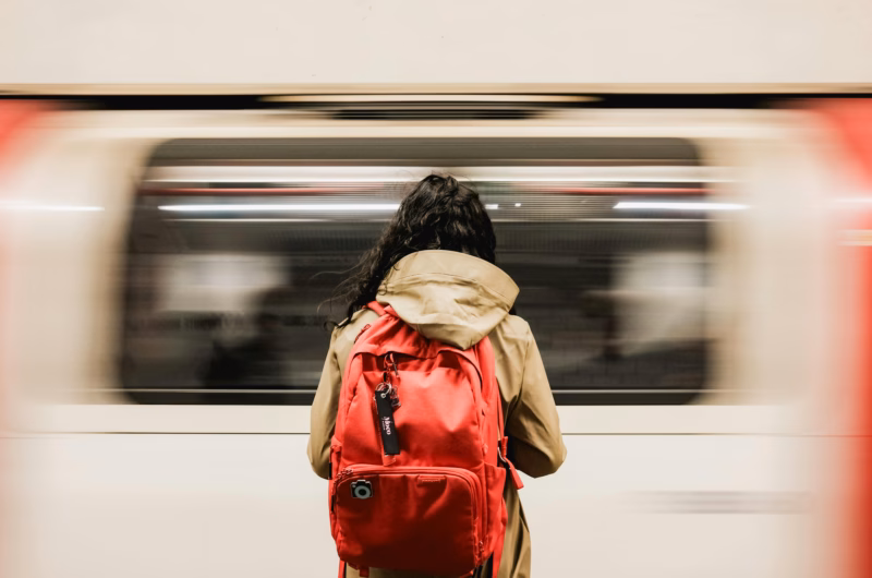 a person waiting for the train with a backpack