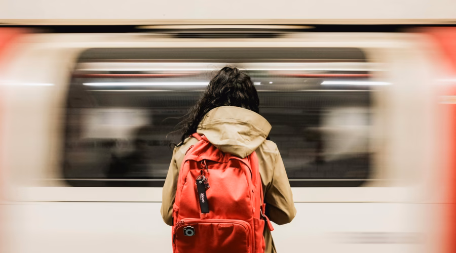 a person waiting for the train with a backpack