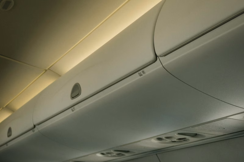 a line of luggage storage solutions in an airplane