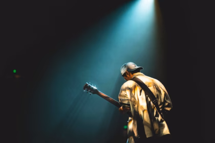 a man is playing the guitar on stage