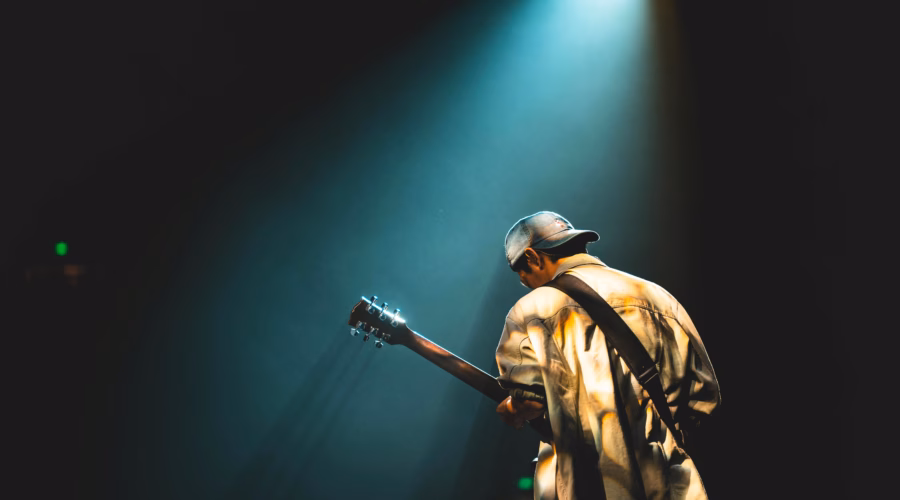 a man is playing the guitar on stage