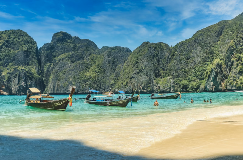 Best time to visit Thailand tropical beach with longtail boats during perfect weather season