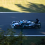 Race car speeding on a dark track.