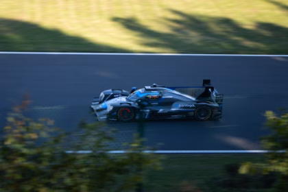 Race car speeding on a dark track.