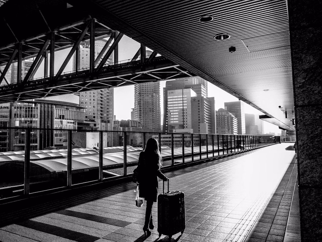 Traveler with luggage outside modern city building
