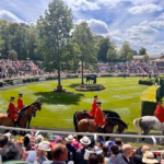 A group of people riding horses on a race track