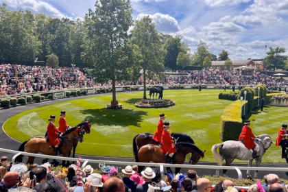 A group of people riding horses on a race track