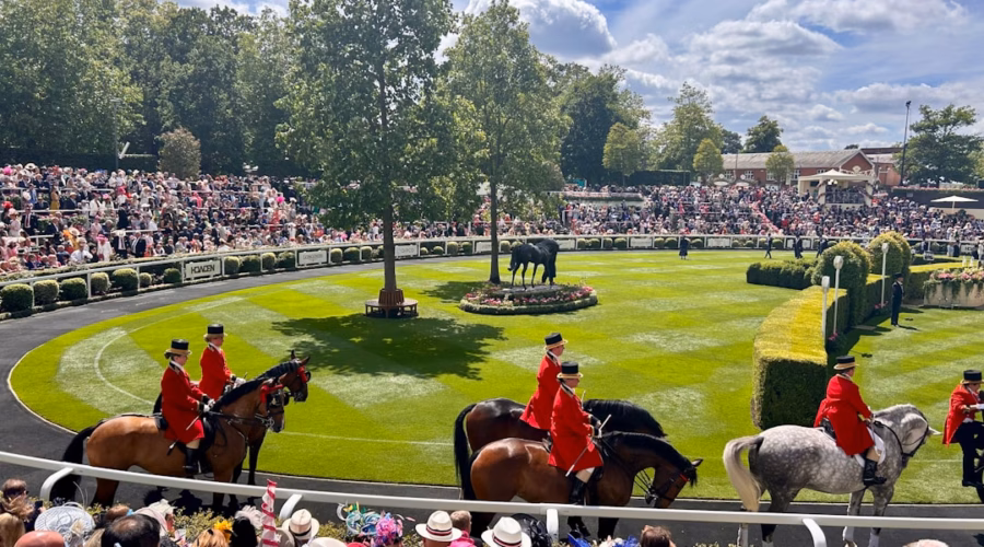 A group of people riding horses on a race track