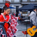 Flamenco dancer in red dress and guitarist performing outdoors.