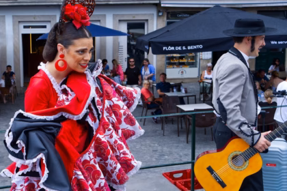Flamenco dancer in red dress and guitarist performing outdoors.