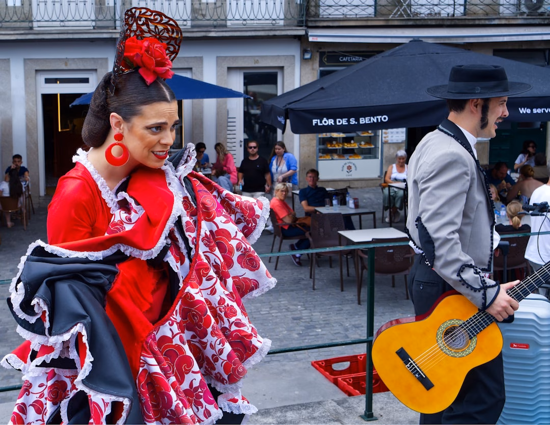 Flamenco dancer in red dress and guitarist performing outdoors.