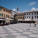 a group of people sitting at tables in a courtyard