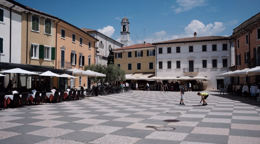 a group of people sitting at tables in a courtyard