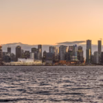 A view of a city from the water at sunset