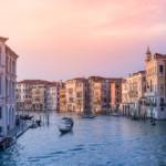 photo of gondolas on body of water between buildings