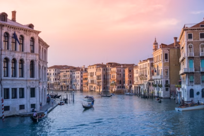 photo of gondolas on body of water between buildings