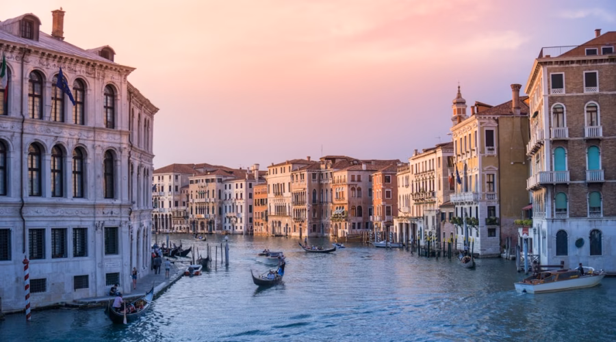 photo of gondolas on body of water between buildings