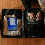 Overhead view of a traveler packing a suitcase for a multi-city trip
