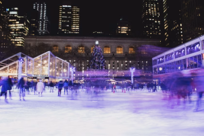 Skaters on an outdoor ice rink at night in New York City