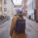 Solo traveller with a backpack walking down a European city street, solo-friendly cities