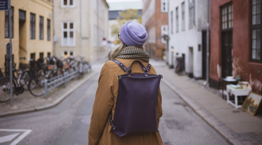 Solo traveller with a backpack walking down a European city street, solo-friendly cities