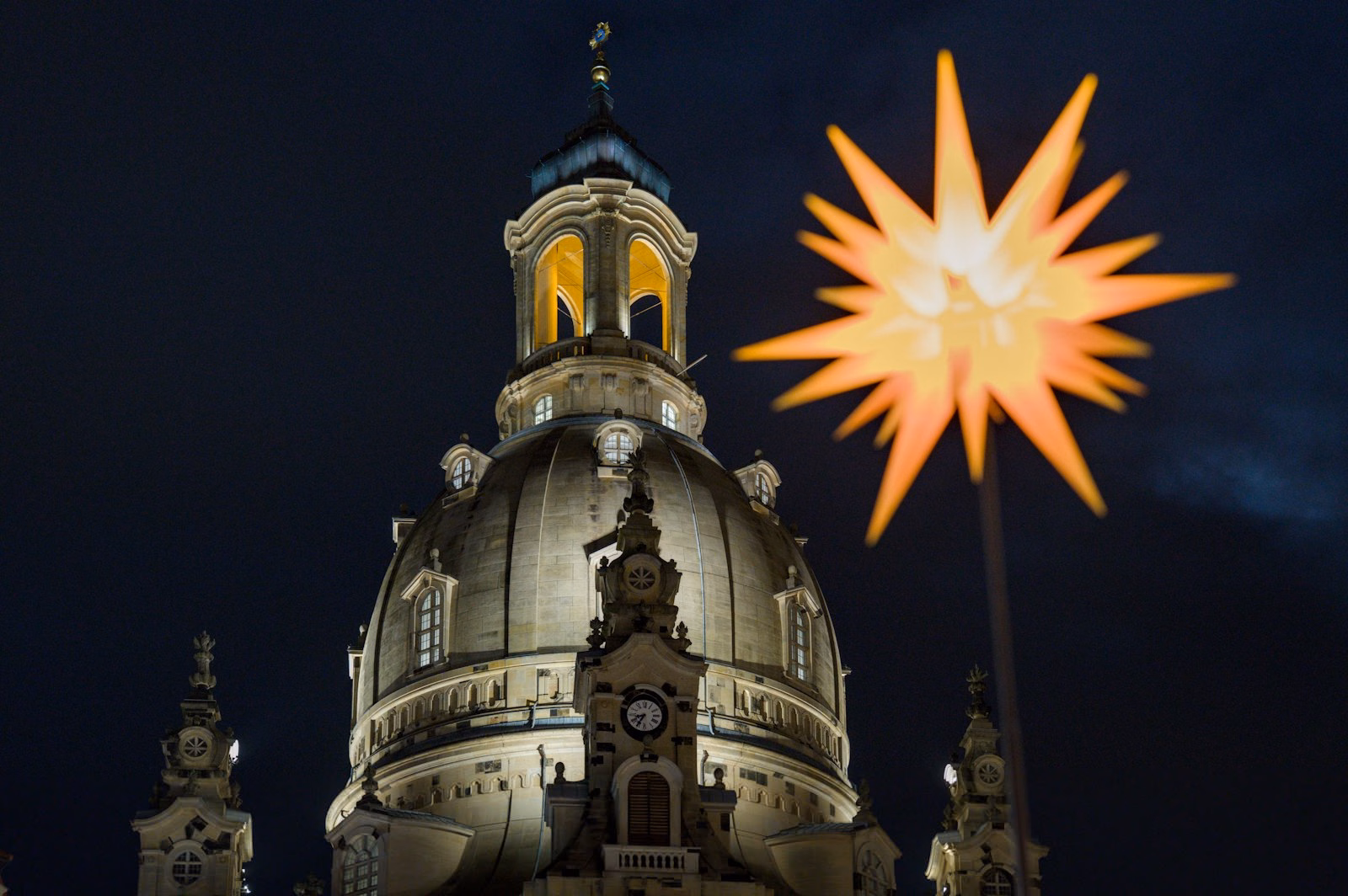 Star decoration and a lit church dome at the Dresden Christmas market